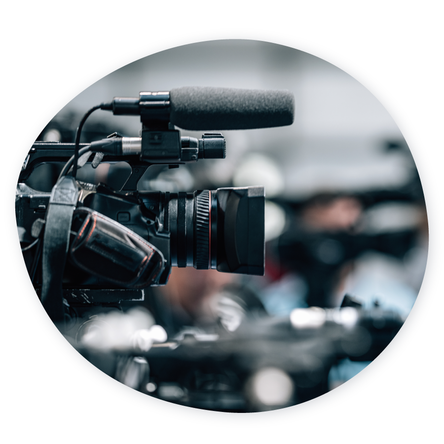 A close-up of a film camera and out-of-focus people in the background.