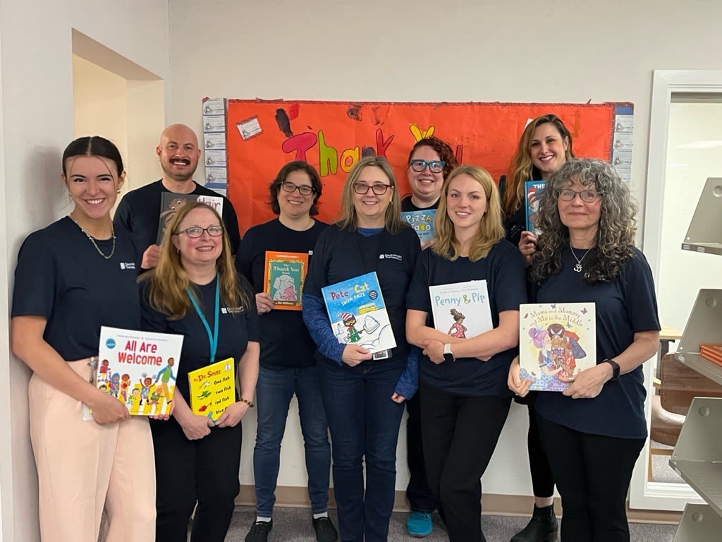 Group of volunteers holding children's books