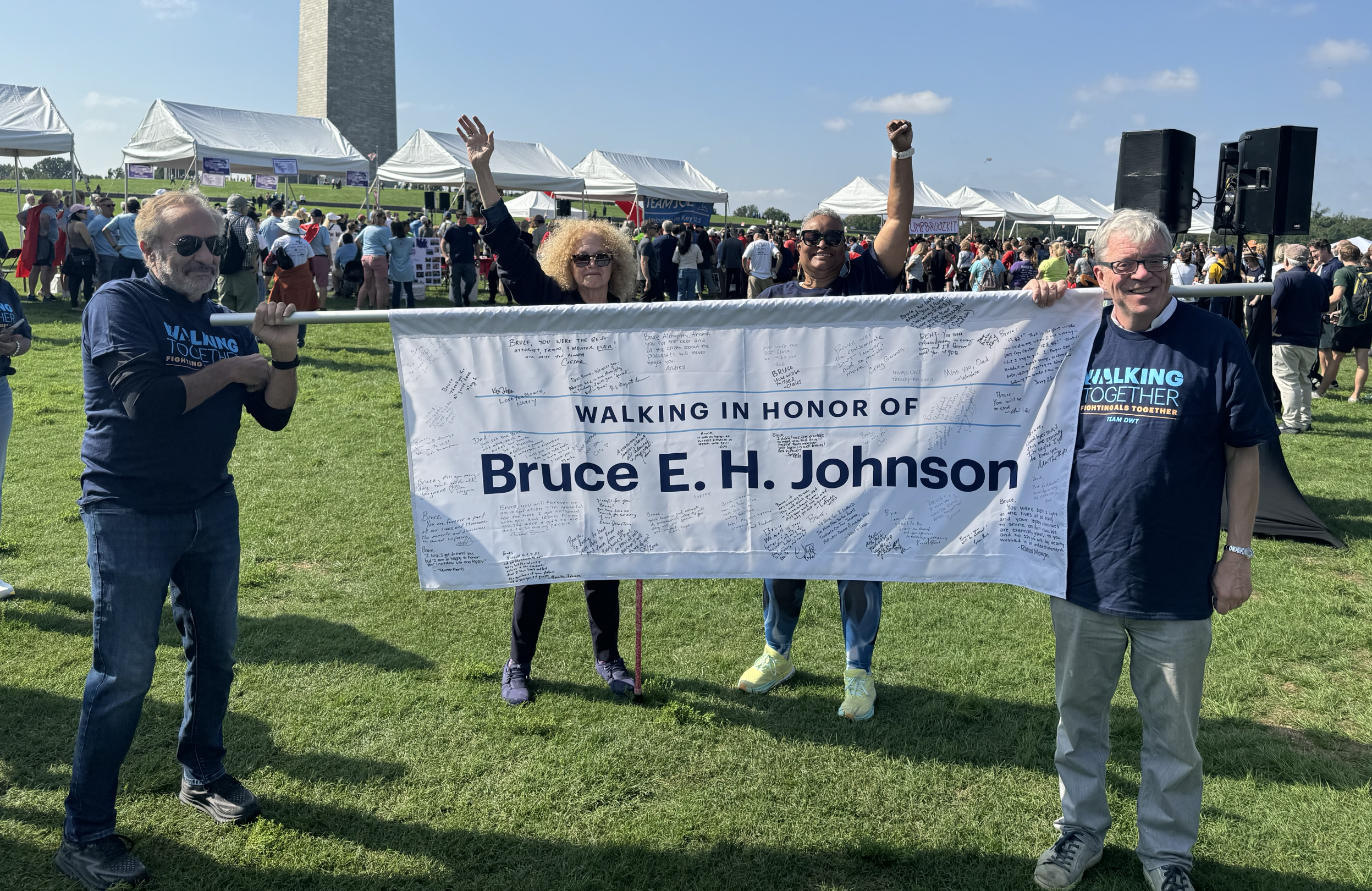 Four DWT-ers holding a banner reading "Walking in honor of Bruce E.H. Johnson" at Seattle ALS Walk